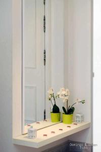 un espejo con dos jarrones en un estante con flores en MARICEL Apartment En la playa, en Calafell