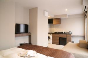 una camera d'albergo con un letto e una cucina di C＆Jホテル a Tokyo