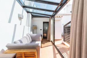 sala de estar con sofá y techo de cristal en Suites San Pablo, en Sevilla