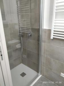 y baño con ducha y puerta de cristal. en Poema Apartment en Casalecchio di Reno