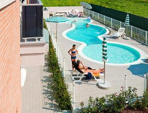 eine Gruppe von Personen in einem Pool in einem Resort in der Unterkunft Casa la Celeste in Bibione