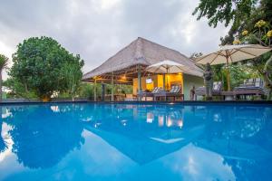 a swimming pool in front of a villa at Komodo Garden in Nusa Lembongan
