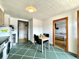 a room with a table and a kitchen with a bed at Residence Louis Petite Maison in Bains-les-Bains