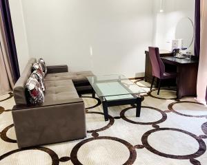 a living room with a couch and a glass table at East Palace Hotel in Almaty