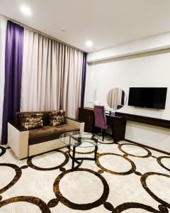 a living room with a couch and a table at East Palace Hotel in Almaty