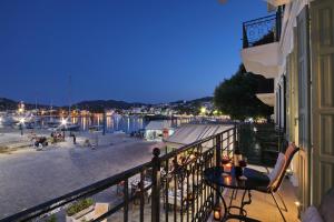 een balkon met een tafel en uitzicht op een haven bij Faros Coastal Apartments in Skopelos Town