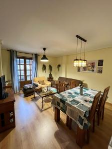 a living room with a table and a couch at Apartamentos Búbal Peña Telera in El Pueyo de Jaca