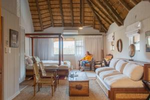 a man is sitting in a living room at Vida Nova Kruger in Marloth Park