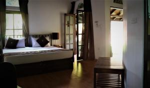 sypialnia z łóżkiem i stołem w obiekcie Pavana Hotel w Negombo