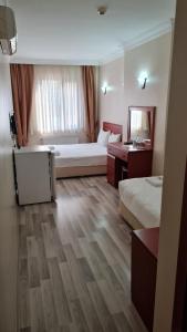 a hotel room with two beds and a mirror at EMOS HOTEL in Istanbul