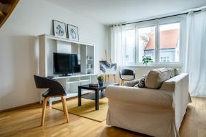 a living room with a couch and a tv at Business & Family Ambiente Apartments in Bratislava