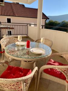 a glass table and chairs on a patio at Lastochka.mne apartments in Baošići