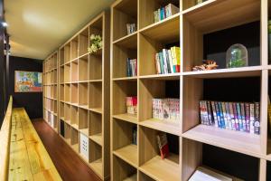 a library with wooden shelves filled with books at Hostel Alley Inn in Daxi