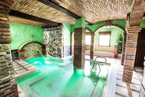 una piscina en una habitación con paredes verdes en Alojamientos Rurales Benarum con Spa, en Alpujarra de la Sierra