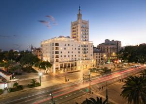 a city with a building and a street at night at Only YOU Hotel Málaga in Málaga