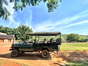 zielony jeep zaparkowany przed polem w obiekcie Zebra Nature Reserve w mieście Cullinan
