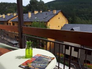 einen Tisch mit einer Zeitschrift und ein Buch auf dem Balkon in der Unterkunft Apartamento Vall Fosca in Senterada