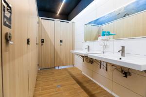 a bathroom with two sinks and wooden cabinets at Hostel Alley Inn -桃園民宿075 in Daxi +19 photos