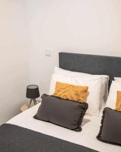 a bed with black and white pillows and a white at Casa do Gato Poeta in Leiria