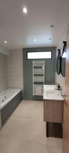 ein Badezimmer mit einer Badewanne, 2 Waschbecken und einer Badewanne in der Unterkunft NeoAppart in Barr