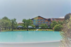 a large swimming pool in front of a building at Hotel Pachernighof in Velden am Wörthersee