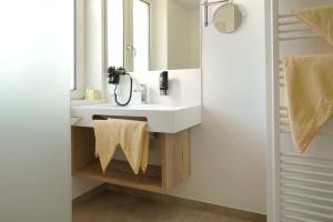 a bathroom with a white sink and a mirror at Hotel Pachernighof in Velden am Wörthersee