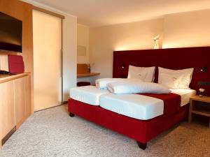 a hotel room with two beds and a television at Hotel Pachernighof in Velden am Wörthersee