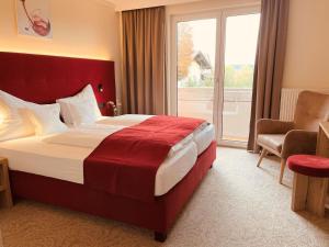 a hotel room with a large bed and a window at Hotel Pachernighof in Velden am Wörthersee