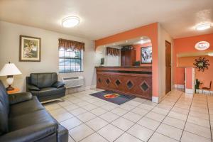 a living room with a couch and a piano at Super 8 by Wyndham San Antonio/I-35 North in San Antonio