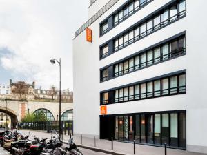 une rangée de motocycles garés devant un bâtiment dans l'établissement Aparthotel Adagio Access Paris Bastille, à Paris