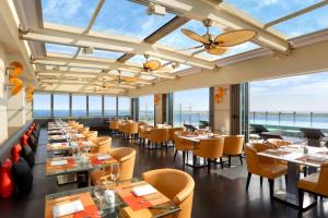 a restaurant with tables and chairs and windows at Jen Maldives Male by Shangri-La in Male City +110 photos