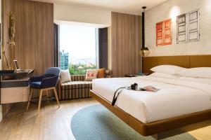 新加坡JEN Singapore Tanglin by Shangri-La的一间配有床、书桌和椅子的酒店房间