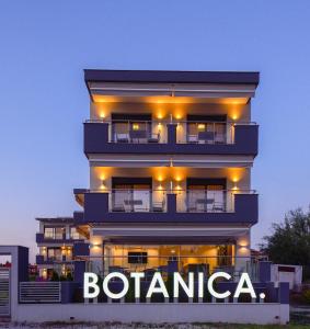a tall building with a sign in front of it at Botanica Luxury Suites in Neos Marmaras