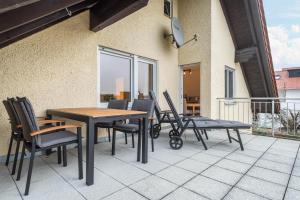 um pátio com uma mesa e cadeiras numa varanda em Ferienwohnung Allgäu em Kisslegg