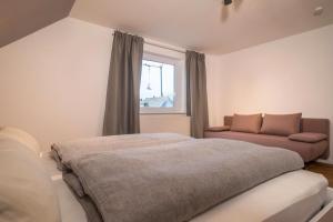 a bedroom with a bed and a couch at Ferienwohnung Allgäu in Kißlegg