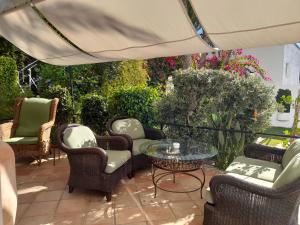a patio with chairs and tables and an umbrella at miKasa Agua Amarga & SPA in Agua Amarga