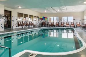 a large swimming pool with chairs and an umbrella at Quality Inn Jacksonville near I-72 in South Jacksonville