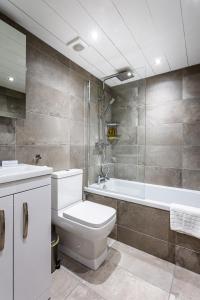 a bathroom with a toilet and a bath tub at Kinloch Hotel, Isle of Arran in Blackwaterfoot