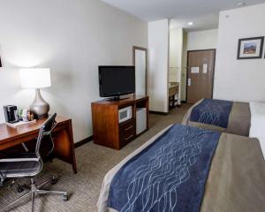 Habitación de hotel con cama, escritorio y TV. en Comfort Inn Kearney - Liberty en Kearney