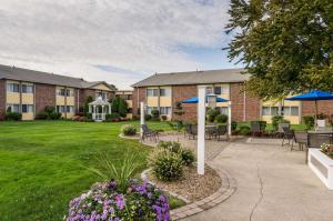 a courtyard with tables and chairs in front of a building at Clarion Hotel Seekonk - Providence in Seekonk