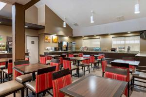 a restaurant with tables and chairs and a counter at Comfort Suites in Columbus