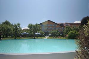 a large swimming pool in front of a building at Hotel Pachernighof in Velden am Wörthersee