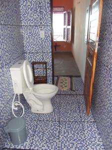 a bathroom with a toilet in a room at CHALÉ COQUEIROS in Icapuí