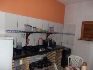 a kitchen with a stove and a counter top at CHALÉ COQUEIROS in Icapuí