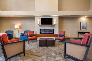 a lobby with chairs and a flat screen tv at Comfort Suites Columbus Airport in Columbus