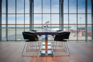 a dining room table with chairs in front of a window at Radisson Blu Airport Terminal Hotel in Arlanda