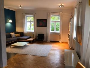 Haus mit Geschichte in Mähring في Mähring: غرفة معيشة مع أريكة ونوافذ