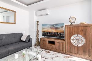 a living room with a couch and a tv at Los Nísperos in Algarrobo-Costa