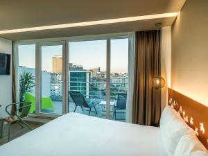 ein Hotelzimmer mit einem Bett und einem großen Fenster in der Unterkunft Ibis Styles Lisboa Centro Marquês de Pombal in Lissabon