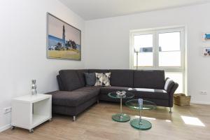 a living room with a couch and a table at Ferienwohnung Himmelblau in Esens